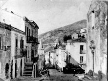 13 Via Vittorio Emanuele e via C. Battisti. Da notare, a destra, il campanile della Chiesa Madre. Cartolina degli anni '50.